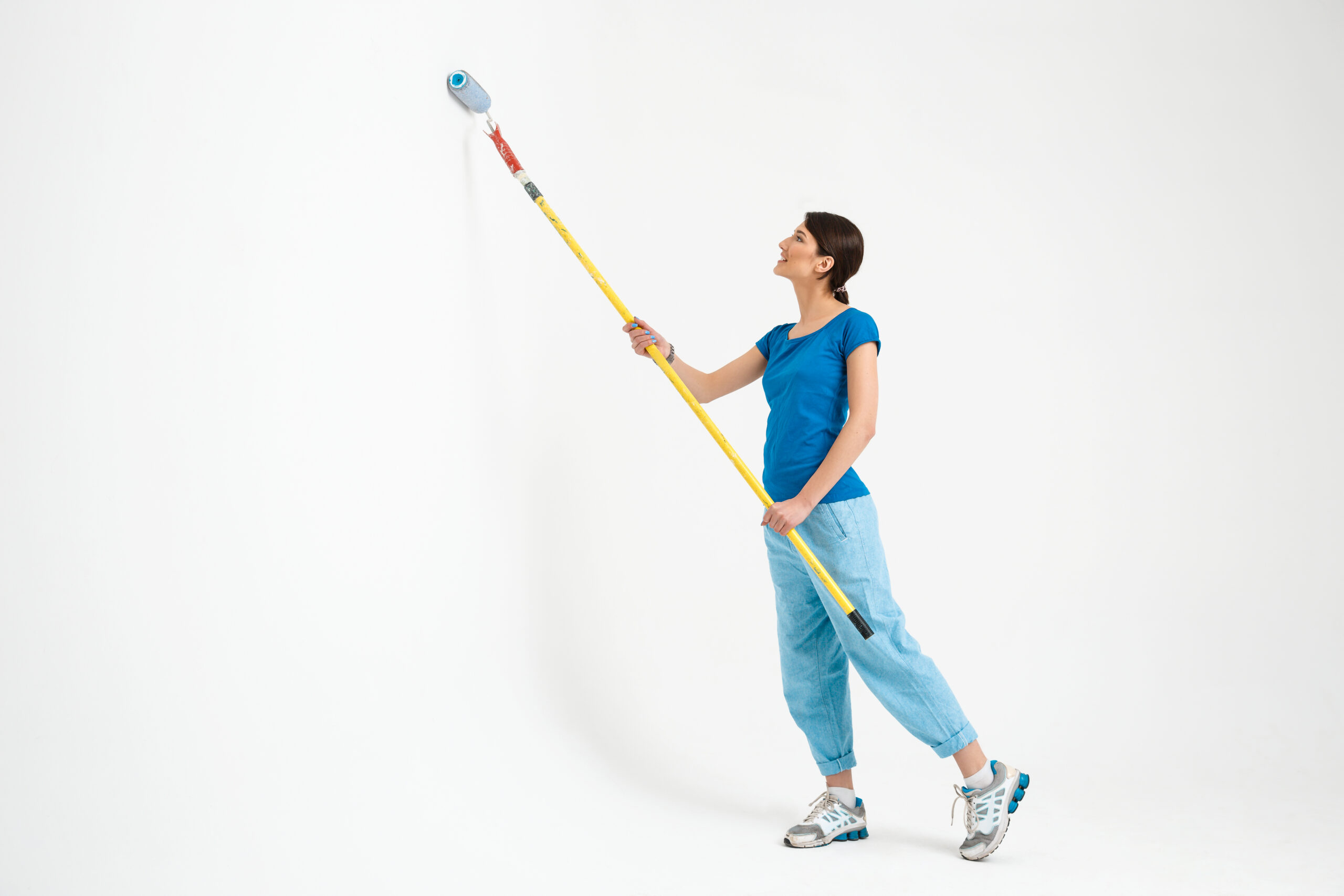 girl painting with roller brush