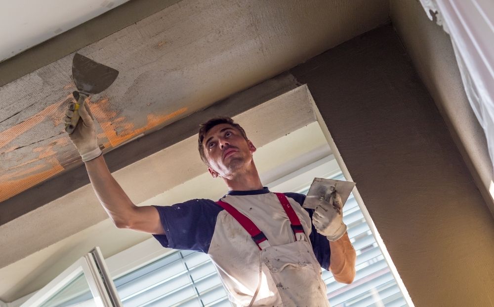 A guy painting the ceiling